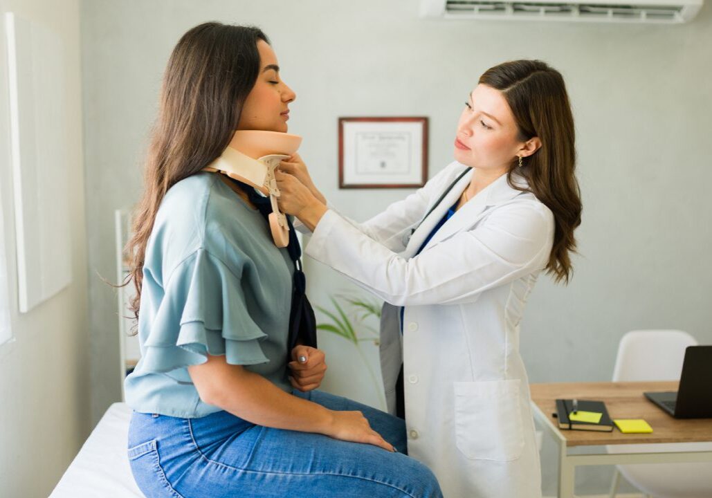Doctor fitting a neck brace on patient.
